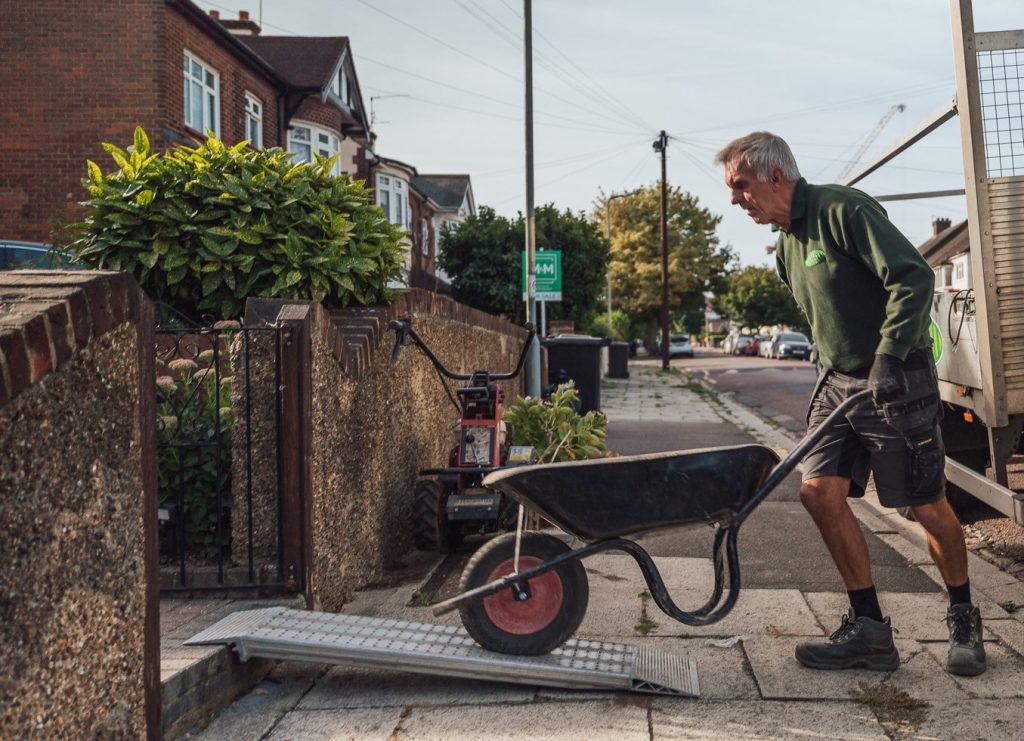 Man pushing wheel barrow or sub-base for lawn installtion